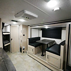 View of Bunks, Bathroom Door, Pantry and Booth Dinette with Storage Cubbies Underneath  May Show Optional Features. Features and Options Subject to Change Without Notice.