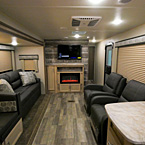 Interior Back to Front View, Showing Part of Booth Dinette, Optional Tri-Fold Sofa, Entertainment Center with T.V. and Optional Fireplace, 2 Lounge Recliners, and part of Counter-Top
 May Show Optional Features. Features and Options Subject to Change Without Notice.