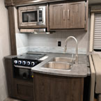 Kitchen - Double Basin Sink, Stovetop, Oven, Microwave, and Overhead Storage Cabinets
 May Show Optional Features. Features and Options Subject to Change Without Notice.
