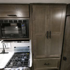 Microwave Overhead of Three Burner Cook Top with Glass Shown Open, Next to Pantry. 
 May Show Optional Features. Features and Options Subject to Change Without Notice.