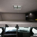 Cab-Over Bunk with TV on a Swivel Arm. 
 May Show Optional Features. Features and Options Subject to Change Without Notice.