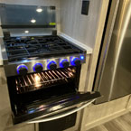 Glass Cover Shown Open to Show Three Burner Cook Top. Oven Door Shown Open with Light On.
 May Show Optional Features. Features and Options Subject to Change Without Notice.