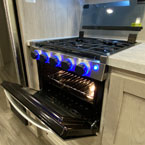 Three Burner Cook with Glass Cover Shown open, Stove Door Shown Open with Oven Light and Blue LED Stove Knobs Shown On. 
 May Show Optional Features. Features and Options Subject to Change Without Notice.