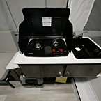 Two Burner Cook Top with Top Shown Open Next to Single Bowl Sink.
 May Show Optional Features. Features and Options Subject to Change Without Notice.