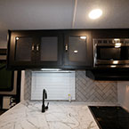 Three Cabinets with Decorative Glass and Microwave Mounted Overhead of Sink and Oven.
 May Show Optional Features. Features and Options Subject to Change Without Notice.